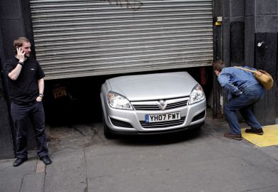 Men looking at car stuck under garage door Men looking at car stuck under garage door