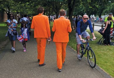 Men walk along wearing matching orange suits Men walk along wearing matching orange suits