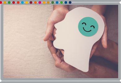Hands holding smiling face in brain paper cutout, to illustrate mental health support.
