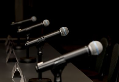 A row of microphones, symbolising debate