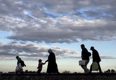 Migrants walk along rail tracks, Roszke, Hungary, 2015