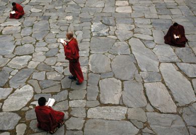 Monks studying books in the courtyard