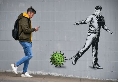 male student walking past wall mural