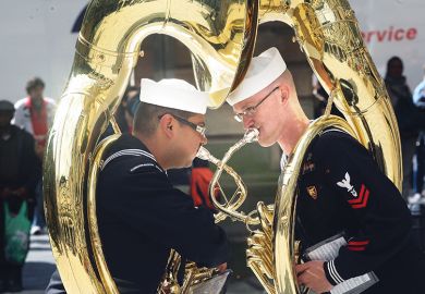 two military sousaphone players as metaphor for two sides uniting  two military sousaphone players as metaphor for two sides uniting
