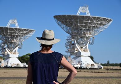 Narrabri, Nsw- MAR 03 2023Australian woman looking at the Telescope Compact Array near Narrabri NSW, that observe star formation, the late stages of stars lives, supernovae and magnetic fields.