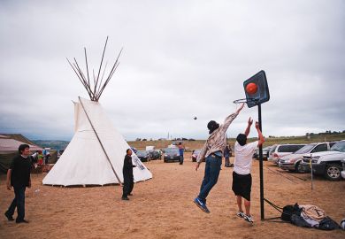 Native American protesters play basketball