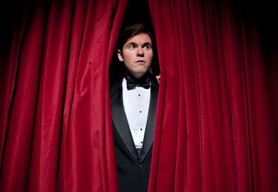 Nervous man peeking through stage curtains