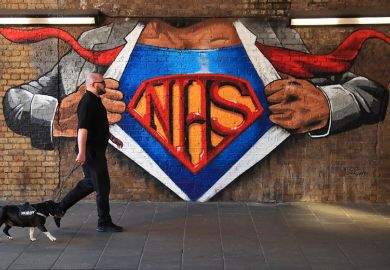 A man and a dog walk past an NHS mural showing superman, illustrating that a new applied research centre focused on NHS transformation could be created.