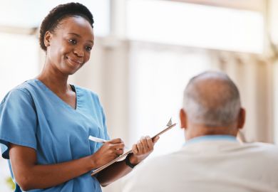 A nurse with a clipboard taking a patient’s details A nurse with a clipboard taking a patient’s details