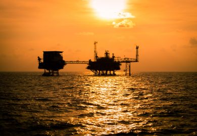 Sunset behind oil rigs, symbolising fossil fuel divestment