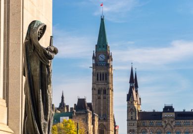 Ottawa, CA - 9 October 2019 Statue Ivstitia (Justice) in front of court Supreme of Canada with Canadian Parliament in background. The statue was made by canadian artist Walter S. Allward circa 1920