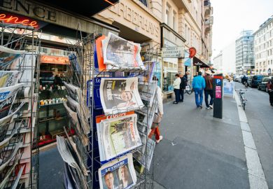 Paris International newspapers at press kiosk wih newspaper and pictures of French Presidential election candidates, Emmanuel Macron, Marine Le Pen a day after first round of French Presidential election on April 23, 2017