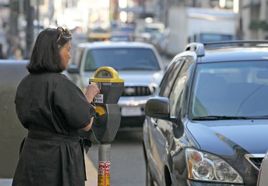 Woman pays a parking meter