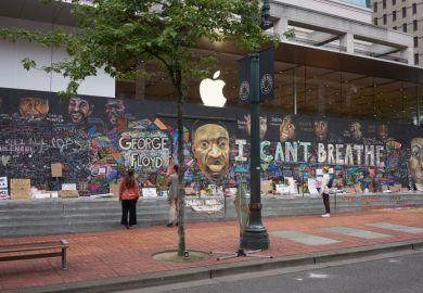 Passers-by stop and take a look at the boarded-up Apple Store in downtown Portland's Pioneer Place, which has become unofficial canvases for peaceful protest.