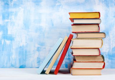 A stack of book beside a blue wall