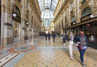 Pedestrians wearing protective face masks in Galleria Vittorio Emanuele II in Milan