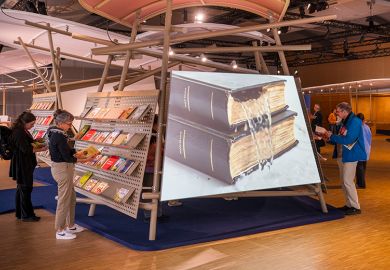 Visitors looking at books at a book fair, with a large image of water pouring out of a book. To illustrate that a number of institutions are predicted to drop deals with main scholarly imprints due to being to costly. Visitors looking at books at a book fair, with a large image of water pouring out of a book. To illustrate that a number of institutions are predicted to drop deals with main scholarly imprints due to being to costly.