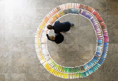 People examining circle of paint swatches, viewed from above