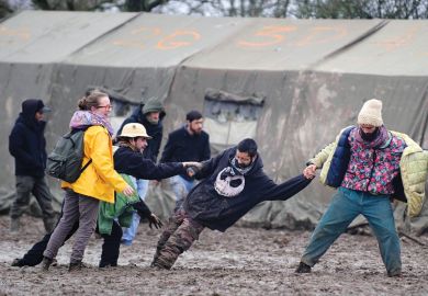 People help man stuck in mud at music festival, Notre-Dame-des-Landes, France People help man stuck in mud at music festival, Notre-Dame-des-Landes, France