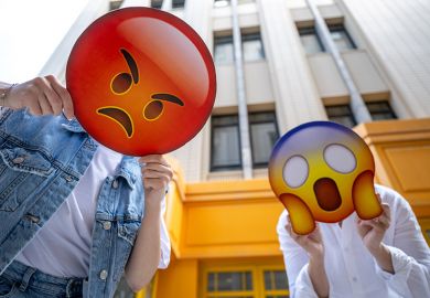 People holding the signs featuring different emoji faces. Too illustrate how neurodiverse and non-English speaking academics can be misunderstood