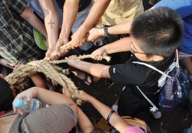 People pulling rope during tug of war festival