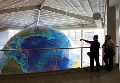 People viewing rotating globe, DeLorme Map Store, Yarmouth, Maine