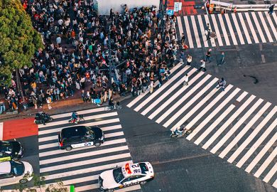 Crowd of people waiting to cross at Shibuya pedestrian crossing, Tokyo, Japan. To illustrate Asian students deciding on where to study, and whether they will switch to cheaper, safer and friendlier options closer to home.