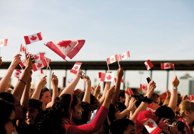 People waving Canadian flags