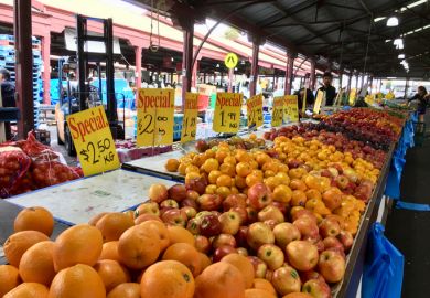 Melbourne, Australia April 12, 2018 People browse the fruit and vegetable stalls at Queen Victoria Market in Melbourne. Prices are displayed over the fruit.