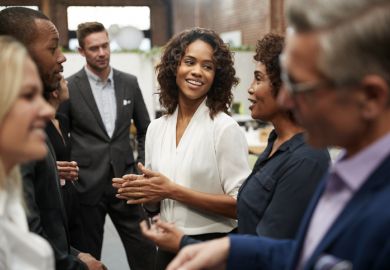 People standing and talking at a conference People standing and talking at a conference