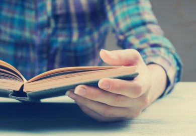 Person sat reading book at table
