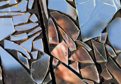 Person reflected in shattered mirror