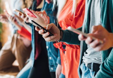 A row of young people on their phones, signifying social media addiction