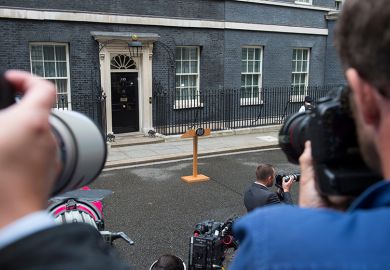 Photographers waiting for an announcement with empty lectern outside Downing Street. To illustrate that universities waiting for government intervention are likely to be disappointed.