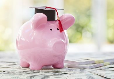 Piggy bank with a graduation mortar board cap concept for the cost of a college education