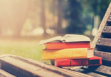 Pile of books on park bench