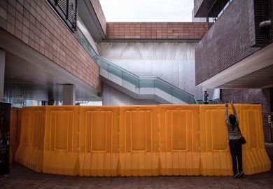 A visitor takes photographs of the "Pillar of Shame" statue site after its removal from the University of Hong Kong (HKU) on December 23, 2021