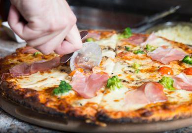 A pizza being sliced A pizza being sliced