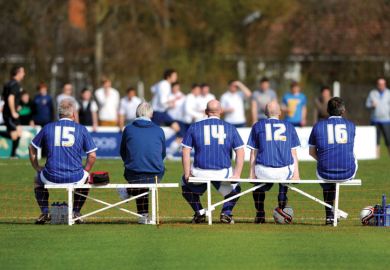 Players sitting on bench at football game Players sitting on bench at football game