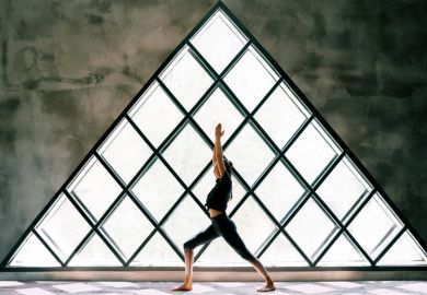 woman doing yoga by large triangular window woman doing yoga by large triangular window