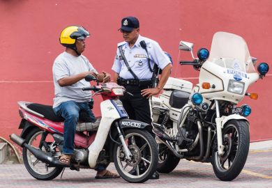 Policeman speaking to motorcyclist, Malacca, Malaysia