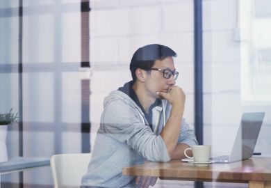 Portrait of Asian businessman thinking when working on computer in office