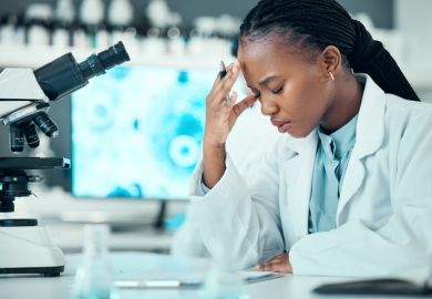 A postdoc holding her head