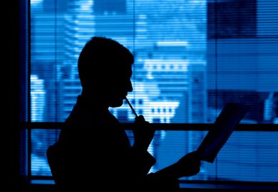 A reviewer in a corporate office ponders a manuscript