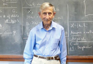 Professor Freeman Dyson standing in front of lecture hall blackboard