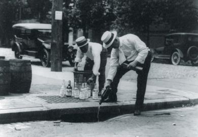 Men pouring alcohol down drain during prohibition