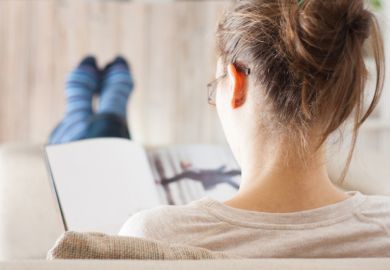 A woman reading a book with her feet up A woman reading a book with her feet up