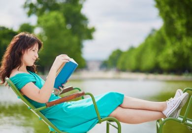 A woman reading a book in the park, symbolising neglect of teaching duties