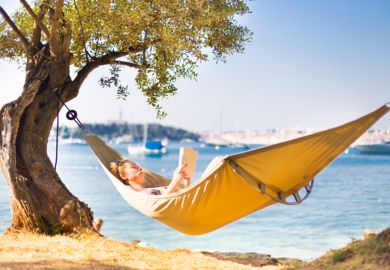A person reading in a hammock