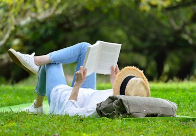A woman lying on her back reading